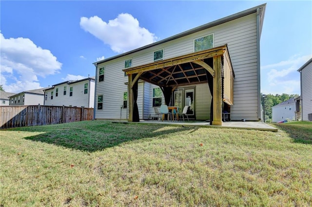 rear view of property featuring a patio and a lawn