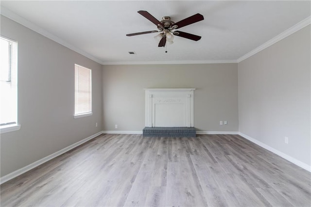 empty room featuring light wood-style flooring, visible vents, baseboards, and crown molding