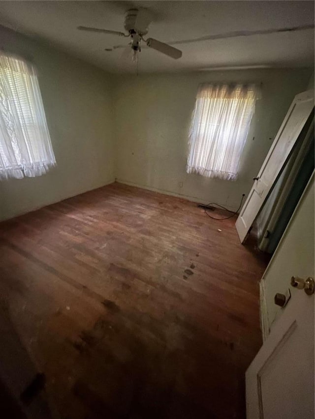 unfurnished room featuring ceiling fan and dark hardwood / wood-style flooring