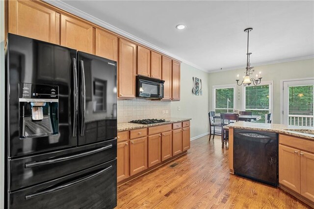 4915 Lazy Creek Ct, Cumming, GA 30028 - kitchen featuring black appliances, a chandelier, ornamental molding, tasteful backsplash, and light stone counters