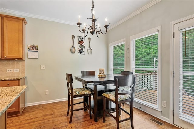 4915 Lazy Creek Ct, Cumming, GA 30028 - dining space with plenty of natural light, a chandelier, light wood-type flooring, crown molding, and baseboards