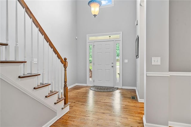4915 Lazy Creek Ct, Cumming, GA 30028 - entrance foyer featuring healthy amount of natural light, a towering ceiling, wood finished floors, and stairs