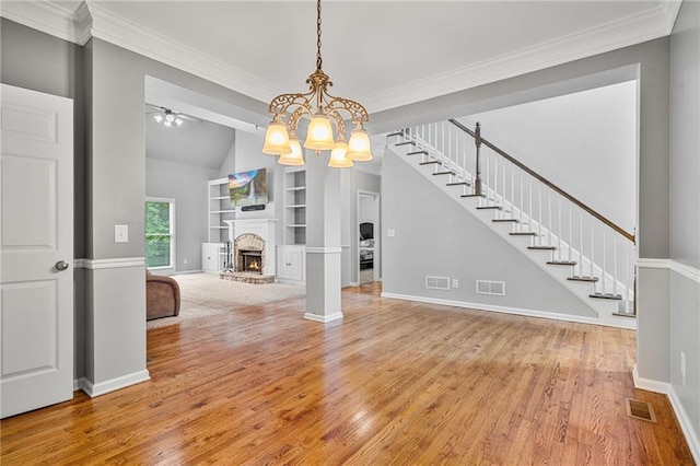 4915 Lazy Creek Ct, Cumming, GA 30028 - unfurnished living room with built in shelves, a brick fireplace, wood finished floors, baseboards, and ornamental molding