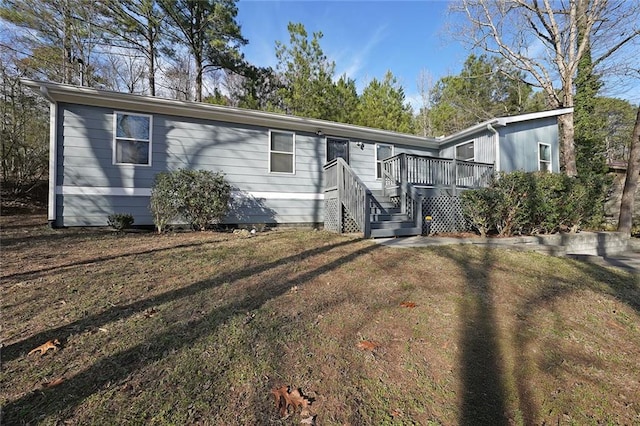 manufactured / mobile home featuring a deck and a front yard