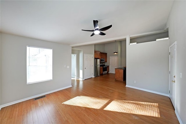 unfurnished living room with light wood finished floors, baseboards, visible vents, ceiling fan, and vaulted ceiling