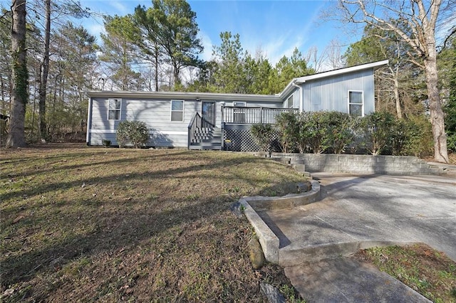 view of front of property featuring a front lawn and a wooden deck