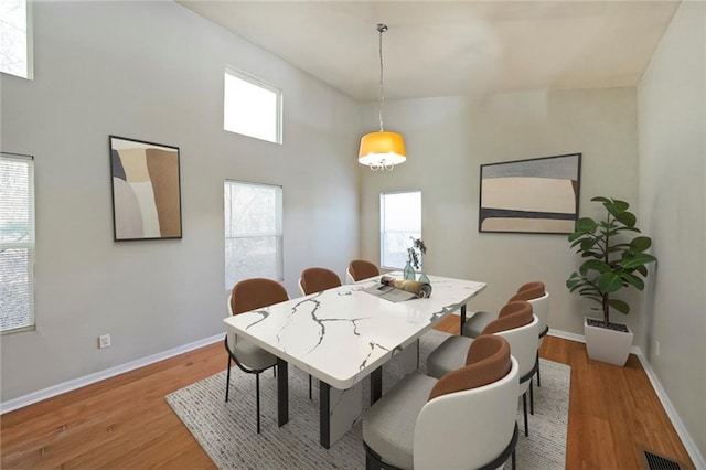 dining area featuring baseboards, visible vents, and light wood-style floors