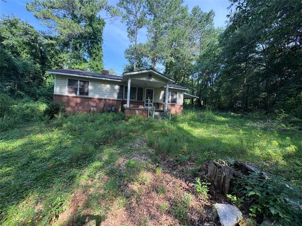 5103 NW Berry St NW, Covington, GA 30014 - view of front of home with brick siding, covered porch, and a chimney