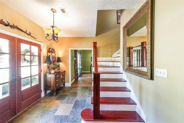 12 Blackfoot Trl, Sharpsburg, GA 30277 - foyer with a textured ceiling, stone tile floors, plenty of natural light, a chandelier, and stairway