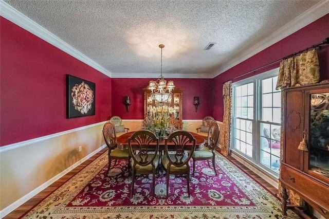 12 Blackfoot Trl, Sharpsburg, GA 30277 - dining space with a textured ceiling, wood finished floors, a chandelier, ornamental molding, and a wainscoted wall