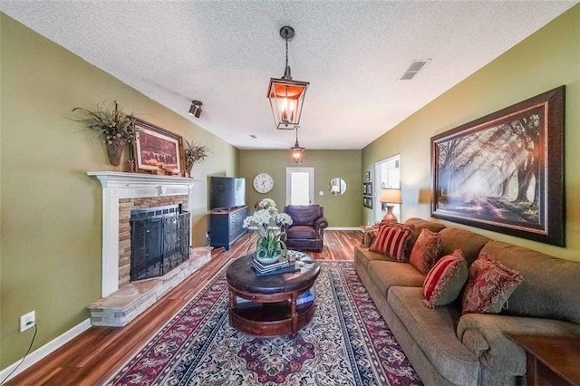 12 Blackfoot Trl, Sharpsburg, GA 30277 - living room with wood finished floors, a textured ceiling, baseboards, and a stone fireplace
