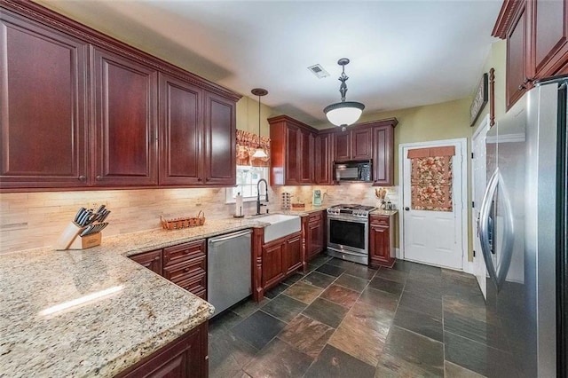 12 Blackfoot Trl, Sharpsburg, GA 30277 - kitchen featuring appliances with stainless steel finishes, a sink, tasteful backsplash, pendant lighting, and dark stone finish flooring