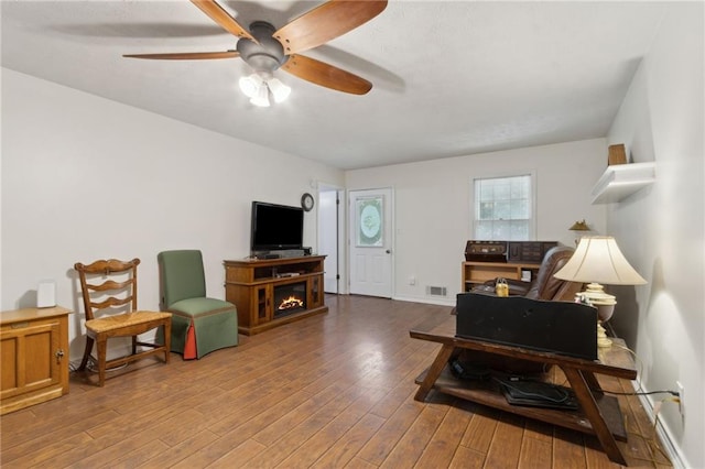 136 Pine St, Covington, GA 30014 - living room with ceiling fan, wood finished floors, and a glass covered fireplace