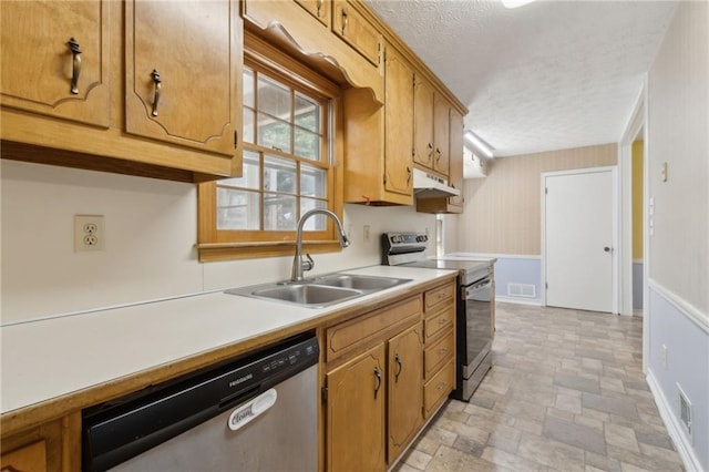 136 Pine St, Covington, GA 30014 - kitchen featuring stainless steel appliances, under cabinet range hood, light countertops, a textured ceiling, and stone finish floors