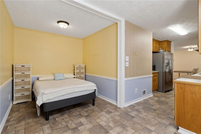 136 Pine St, Covington, GA 30014 - bedroom featuring stainless steel refrigerator with ice dispenser, light stone finish flooring, and a textured ceiling