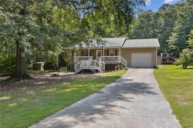 136 Pine St, Covington, GA 30014 - single story home with a porch, driveway, a front lawn, an attached garage, and a metal roof