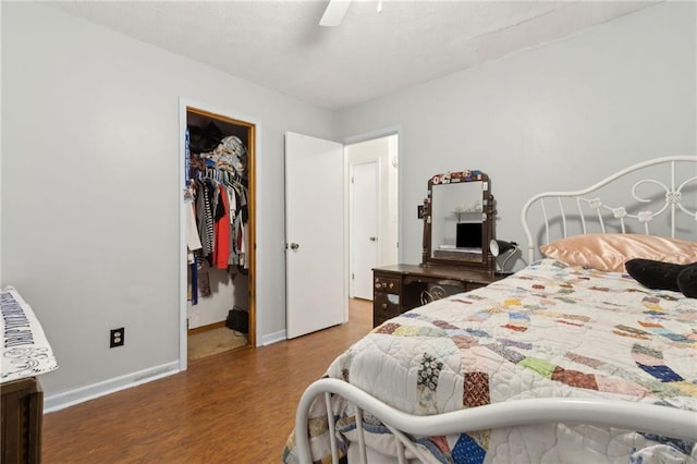 136 Pine St, Covington, GA 30014 - bedroom featuring wood finished floors, a walk in closet, a closet, and ceiling fan