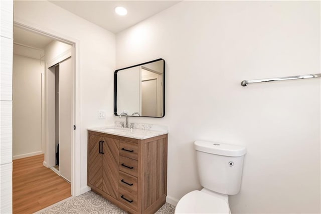 bathroom featuring hardwood / wood-style flooring, vanity, and toilet