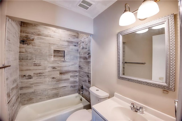 full bathroom featuring tiled shower / bath combo, vanity, and toilet