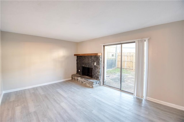 unfurnished living room featuring a fireplace and light hardwood / wood-style floors