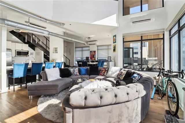 living room with hardwood / wood-style flooring and a wall mounted AC