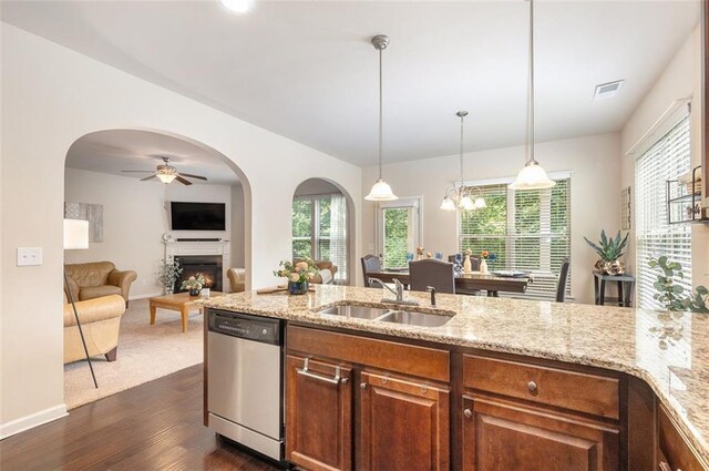 2149 Apple Orchard Way, Austell, GA 30168 - kitchen featuring stainless steel dishwasher, a sink, a lit fireplace, light stone countertops, and dark wood-style flooring