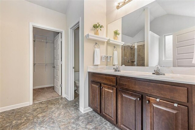 2149 Apple Orchard Way, Austell, GA 30168 - bathroom with a stall shower, toilet, lofted ceiling, a walk in closet, and double vanity