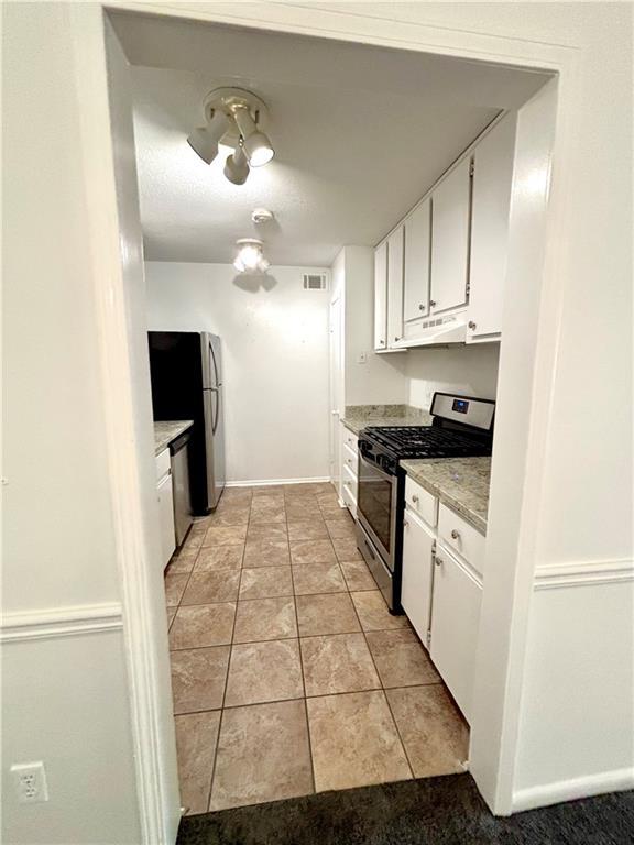kitchen featuring visible vents, white cabinets, baseboards, light countertops, and appliances with stainless steel finishes