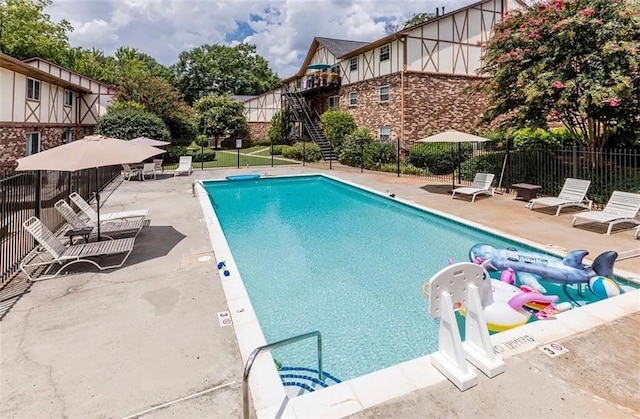 community pool featuring fence and a patio