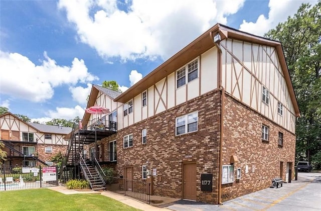 view of building exterior with fence and stairway