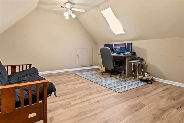 office space with light hardwood / wood-style floors, ceiling fan, and lofted ceiling with skylight