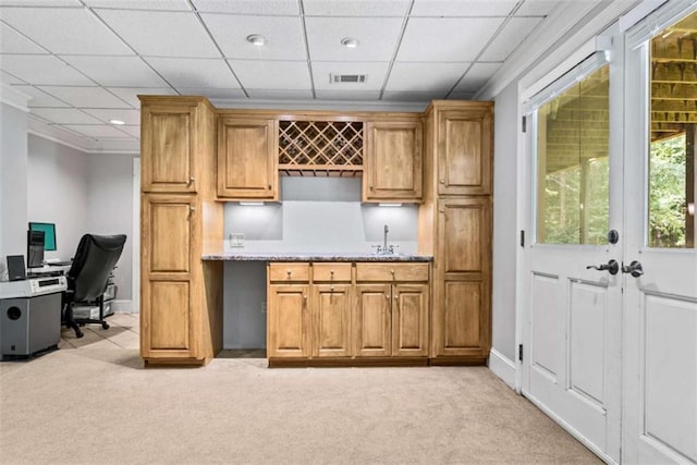 bar with sink, a paneled ceiling, and light carpet