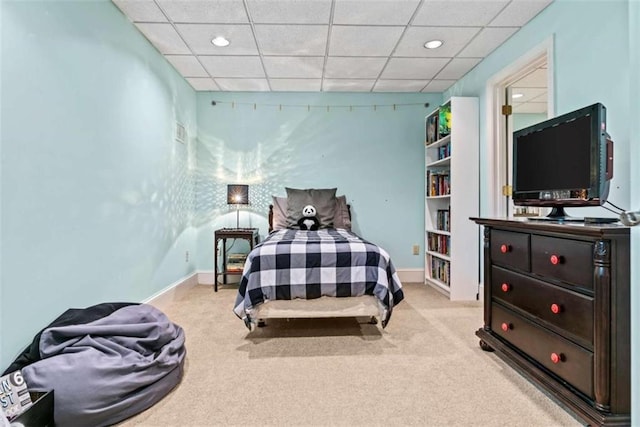 bedroom with a paneled ceiling and light colored carpet