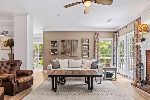 living room featuring ceiling fan, ornamental molding, and light hardwood / wood-style floors