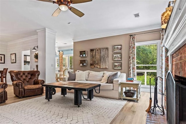 living room featuring ornate columns, ceiling fan, light hardwood / wood-style flooring, and crown molding