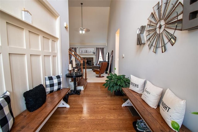 corridor with hardwood / wood-style flooring and a high ceiling