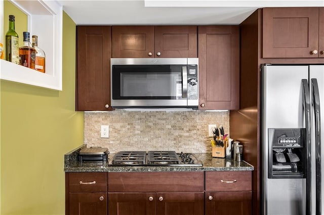 kitchen with dark stone countertops, tasteful backsplash, and appliances with stainless steel finishes