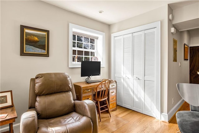 home office with light wood-style floors and baseboards