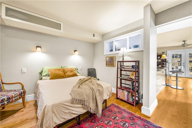 bedroom with visible vents, baseboards, and wood finished floors