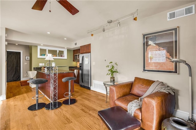 interior space featuring visible vents, indoor bar, ceiling fan, light wood-type flooring, and rail lighting