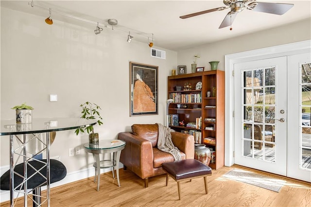 sitting room featuring visible vents, baseboards, a ceiling fan, and wood finished floors