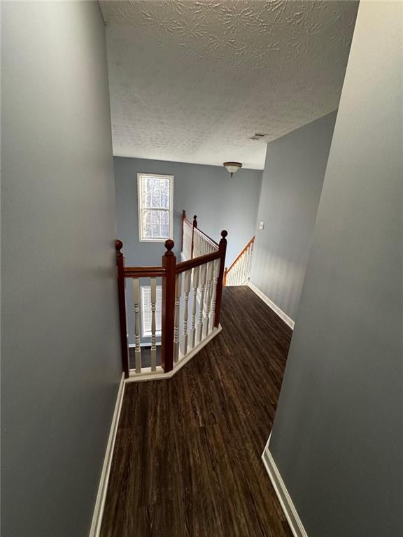 staircase featuring wood-type flooring and a textured ceiling