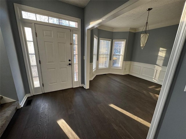 foyer entrance featuring dark hardwood / wood-style flooring, a healthy amount of sunlight, and a textured ceiling