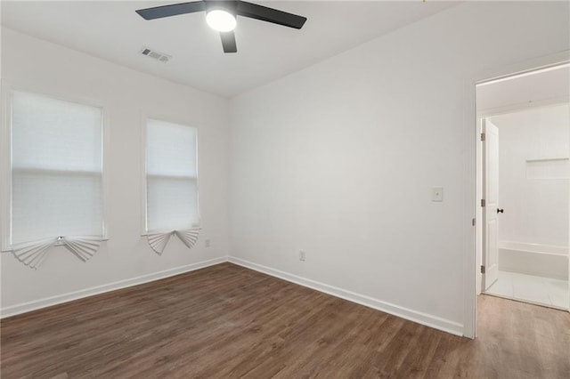 empty room with baseboards, visible vents, ceiling fan, and wood finished floors