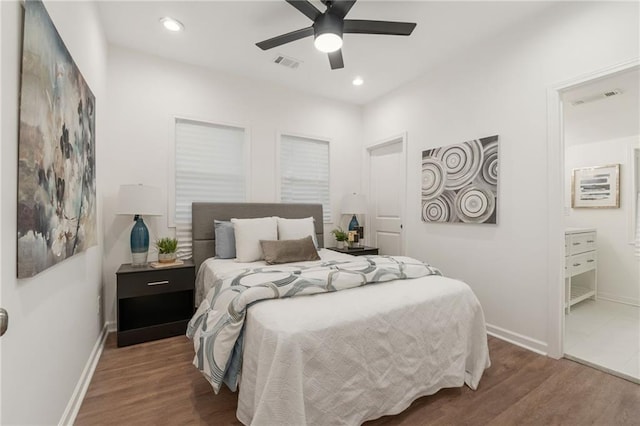 bedroom with visible vents, baseboards, and wood finished floors