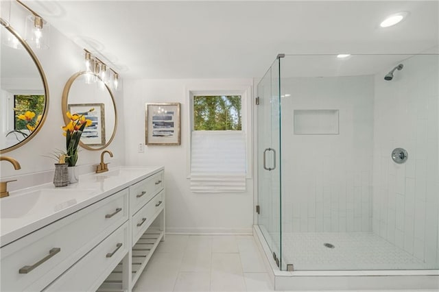 full bath featuring baseboards, double vanity, a sink, and a shower stall