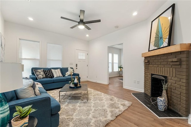 living room featuring recessed lighting, a fireplace, wood finished floors, and baseboards