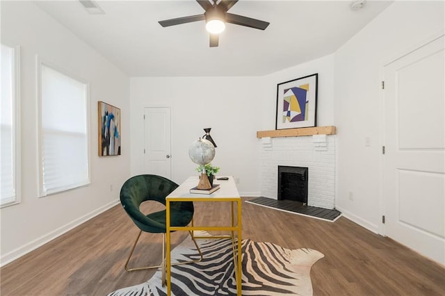 interior space with a fireplace, wood finished floors, and baseboards