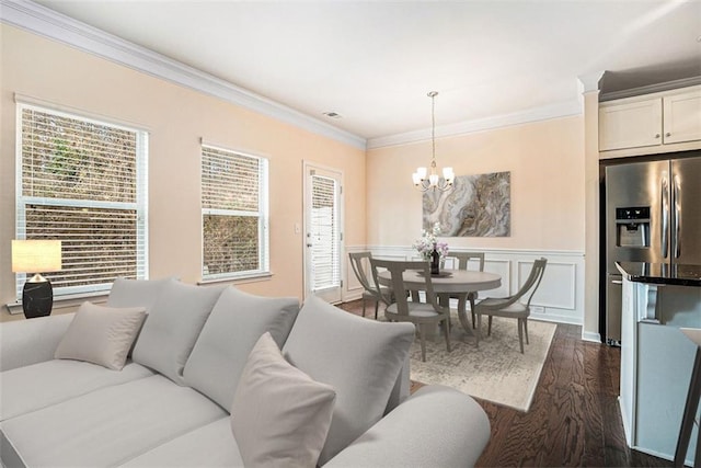 living room with a chandelier, dark hardwood / wood-style flooring, and ornamental molding