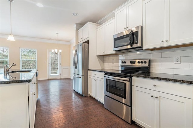 kitchen with sink, hanging light fixtures, white cabinetry, and stainless steel appliances